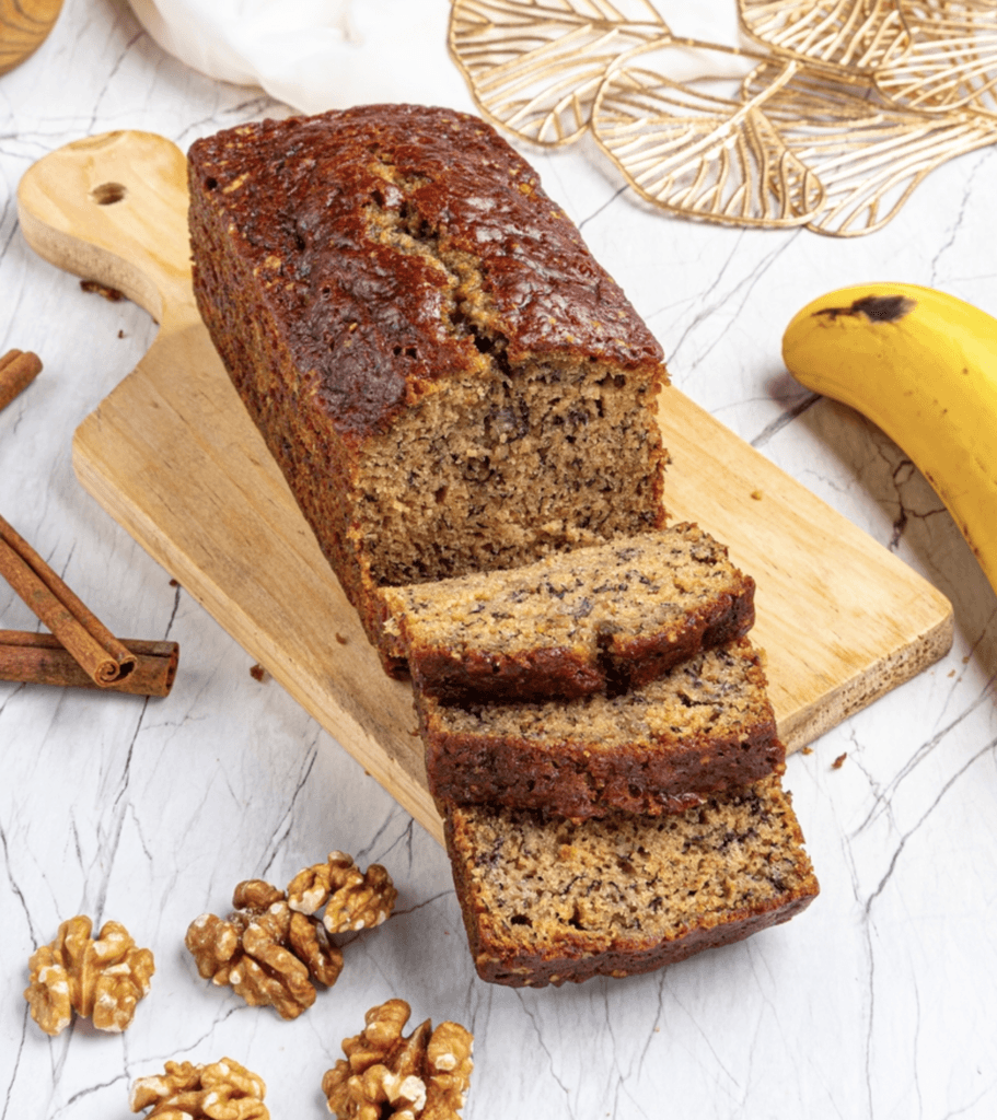 Freshly baked banana bread made with cake mix, sliced on a wooden board