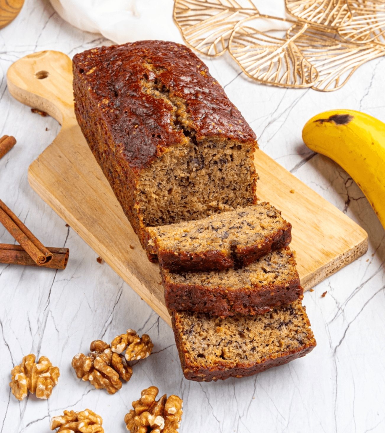 Freshly baked banana bread made with cake mix, sliced on a wooden board